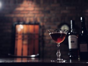 BAR ALBA（バー・アルバ）オリジナルカクテル『ダスク・アイランド』の写真。レンガ壁を背景に、静かな光をまとったグラスが幻想的に浮かび上がる、大人のバーの一瞬を切り取った一枚。
