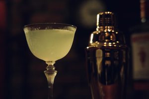 シェイカーと並ぶラストワードのカクテル。バーテンダーの技術が光る一杯。BAR ALBA店内で撮影された写真。