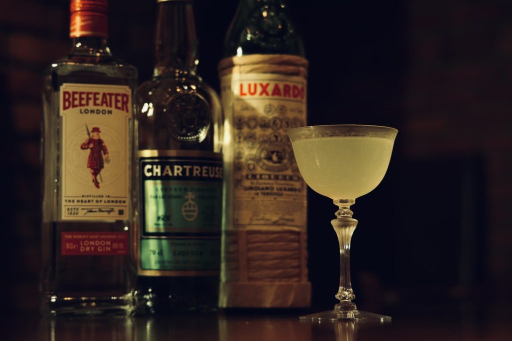 ラストワードに使用されるジン、グリーンシャルトリューズ、マラスキーノのボトルと完成したカクテル。BAR ALBAにて撮影。