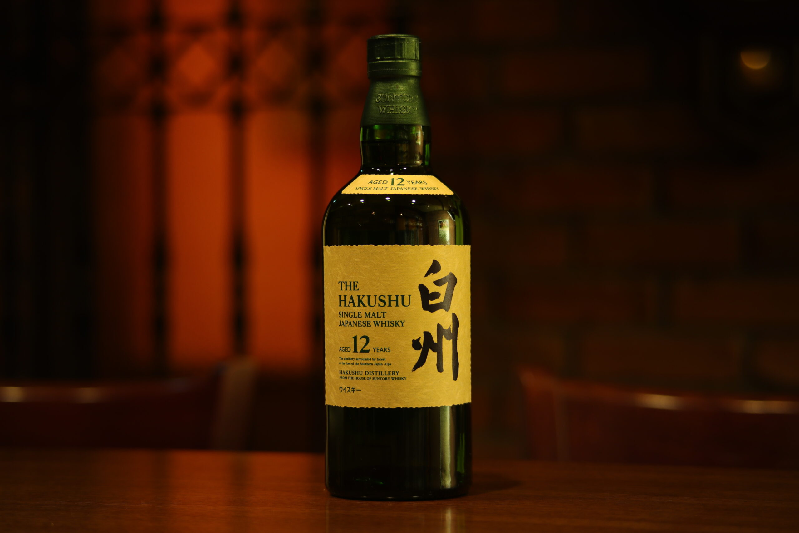 白州12年のボトル。深い緑のガラスに金色のラベルが映える。BAR ALBAの温かな照明のもとで撮影。