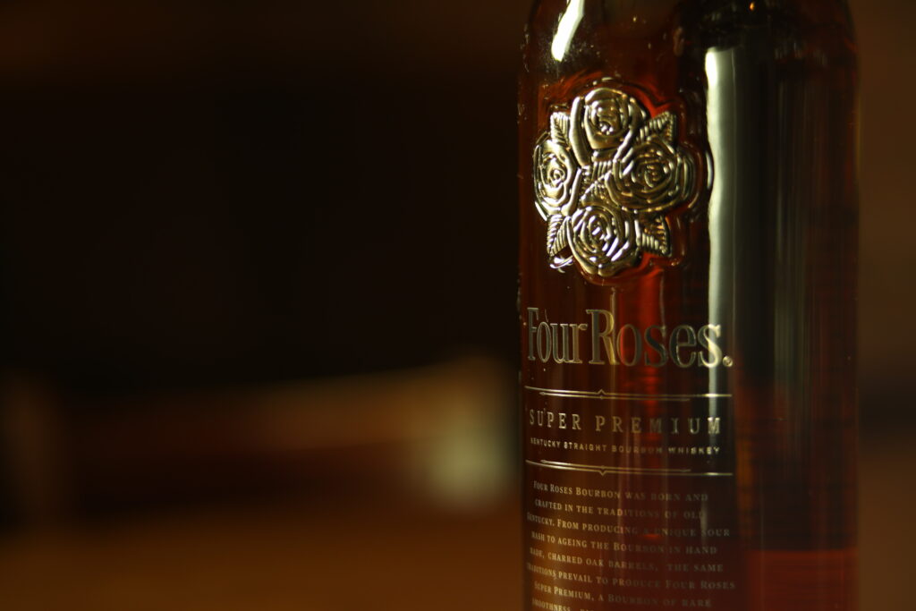 フォアローゼズ・プラチナのロゴと琥珀色の液色をクローズアップで写した写真。
Close-up of the Four Roses Platinum logo and the bourbon’s amber color.