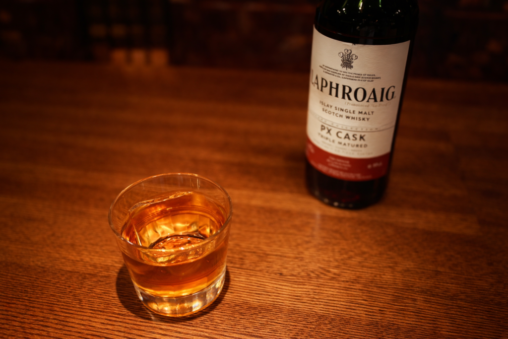 ラフロイグPXカスクをロックグラスで注いだウイスキーとボトルのバー店内写真